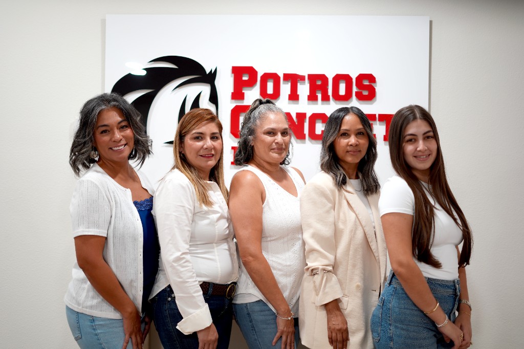 The Potros Concrete office team in front of the company sign
